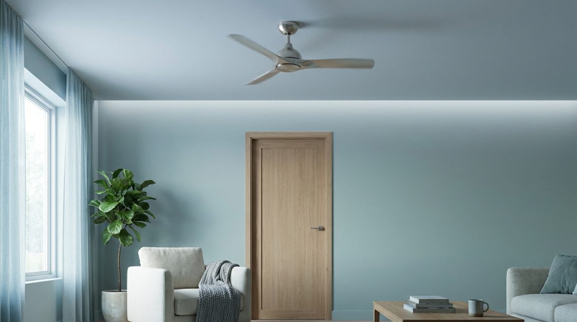 Un ventilateur de plafond tourne au-dessus d'une porte fermée dans un salon aux murs bleus, avec plante et mobilier clair.