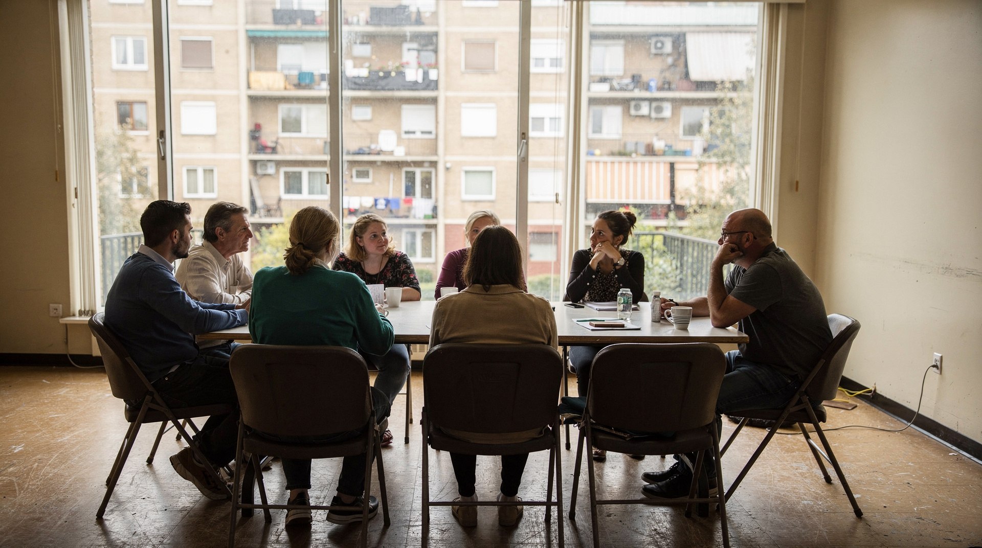 Assemblée générale de copropriété autour d'un plan d'immeuble